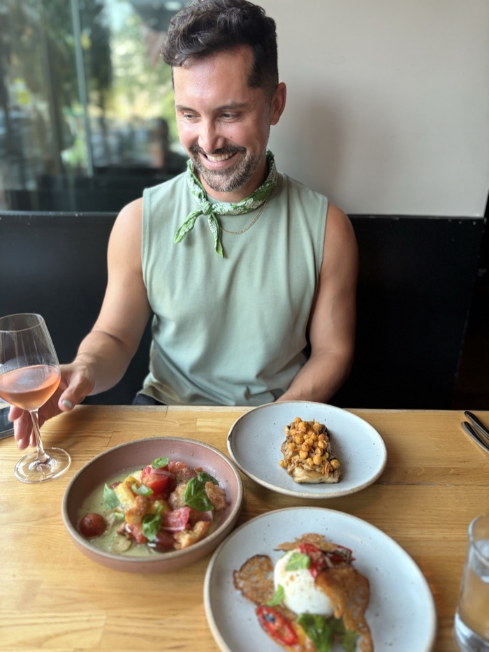 AJ Dronkers at a restaurant table with a glass of rosé